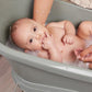 Breeze green baby bath tub on stand with a reclining infant inside