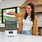 Baby bottle sterilizer dryer beside kitchen counter, lid being lifted by a person.