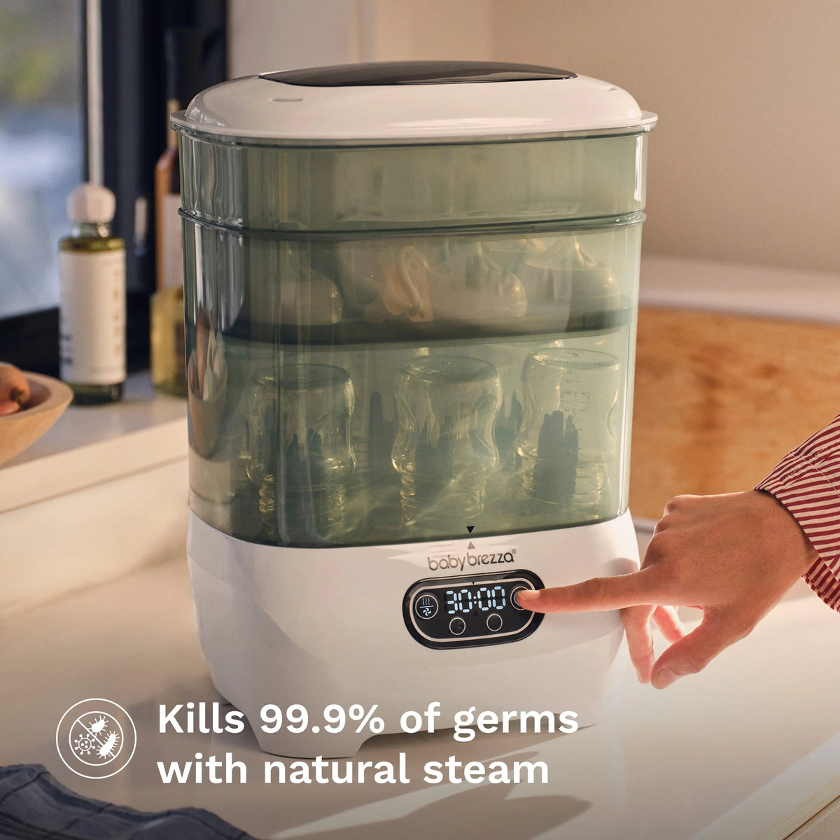Baby bottle sterilizer dryer on countertop with clear steaming chamber and front LCD panel