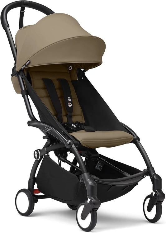 Tan canopy stroller with black frame, front wheels and footrest visible