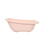 Pale pink plastic bath tub with wide rim and drain plug