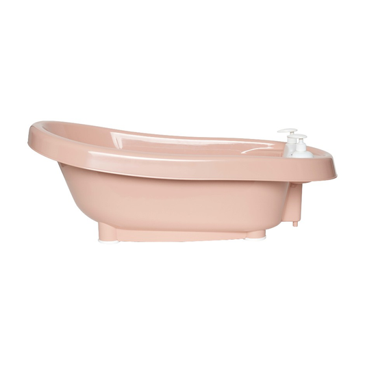 Pale pink freestanding bathtub with built-in faucet and handheld soap dispenser