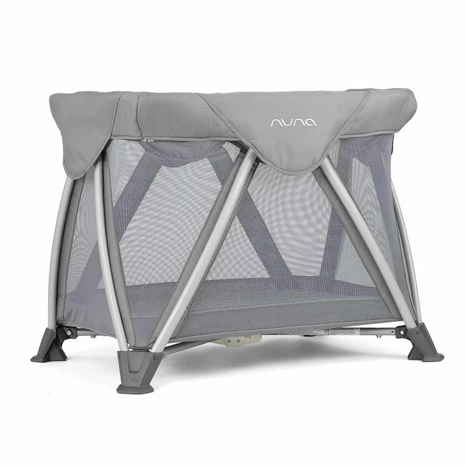 Nuna bedside bassinet with gray canopy, mesh sides, and foldable stand