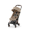 Ultra-compact stroller with beige canopy and seat, rose-gold frame, three-quarter view