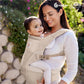 Beige hip seat baby carrier with baby inside and front panel pocket