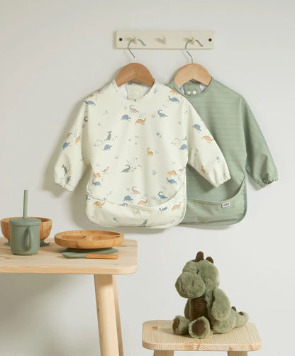 Two long-sleeve baby bibs: cream dinosaur print and sage green bib set.